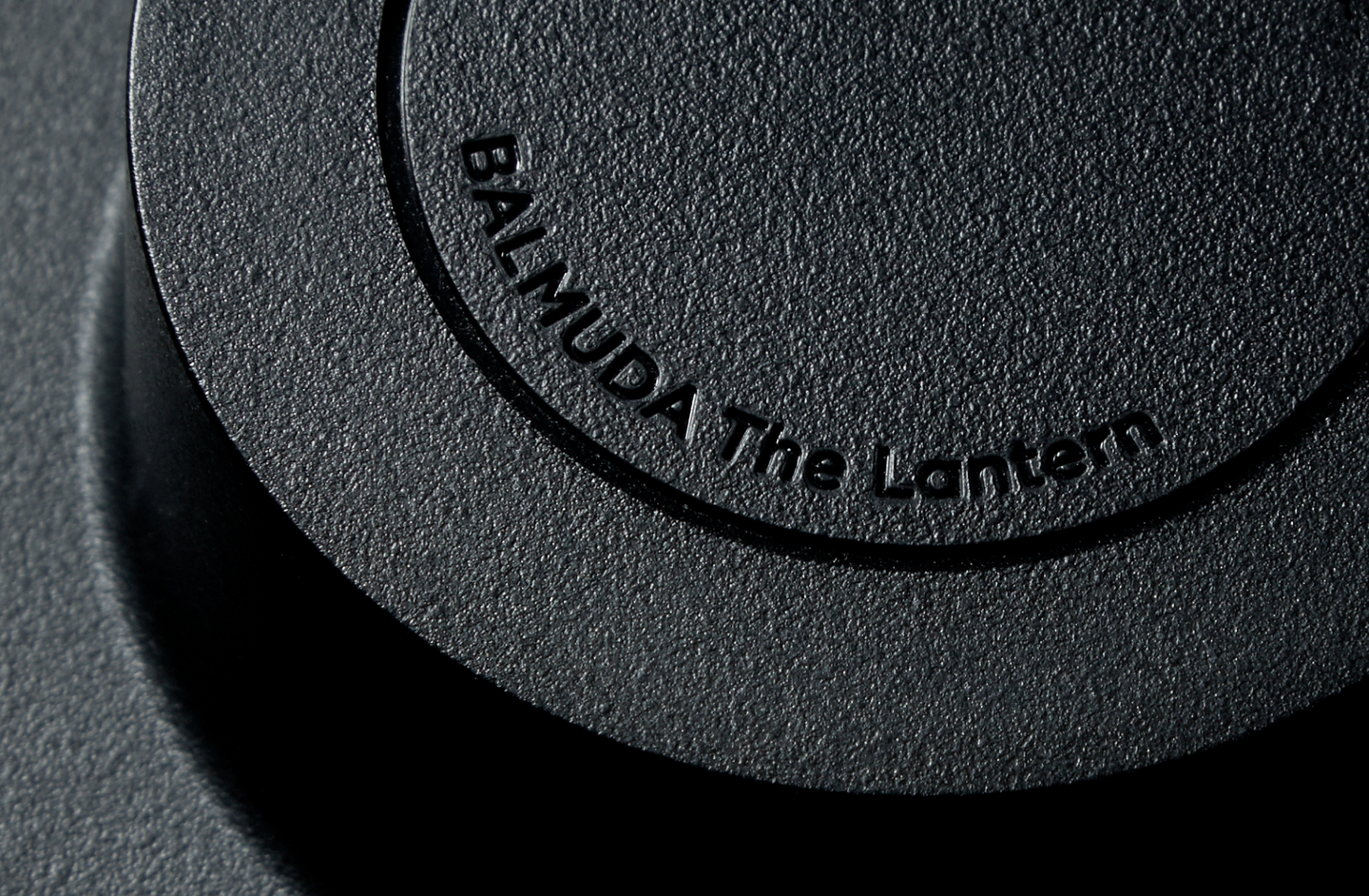 Close-up of the textured black surface of BALMUDA The Lantern, showing the engraved product name on the top.